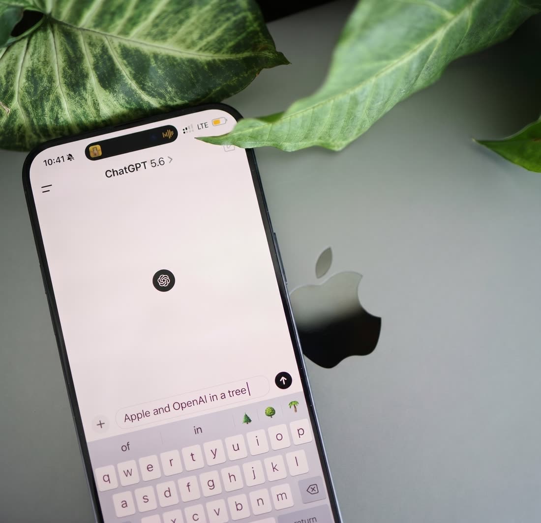Un téléphone affichant ChatGPT, posé parmi des feuillages